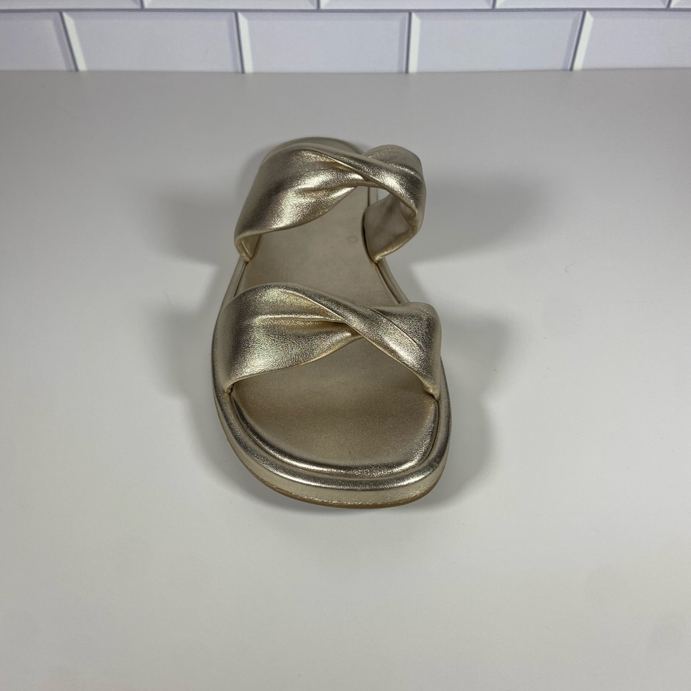 Gold metallic slide sandals with a knot detail on the toe strap